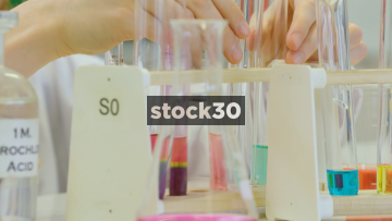 Scientist Comparing Coloured Liquids In Chemistry Lab