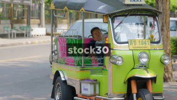 A Thai Man Asleep In A Tuk Tuk In Bangkok, Thailand