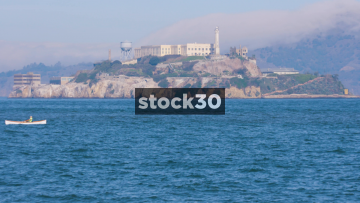 Alcatraz Prison In San Francisco With Man Rowing Past In Boat, USA